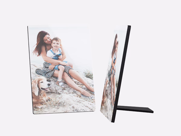 Ein Fotoaufsteller zeigt ein schönes Bild von einer jungen Frau, einem kleinen Kind und einem goldenen Retriever-Hund. Die Frau hat lange, braune Haare und trägt ein gemustertes Top und einen Rock. 